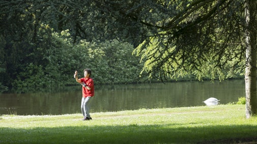 A woman teaching Tai Chi in front of a lake